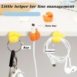 Colorful thumb-shaped cable clips holding a charging wire on a desk