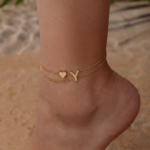 Woman wearing a Letter Y Heart Anklet with a double-layer chain and heart charm