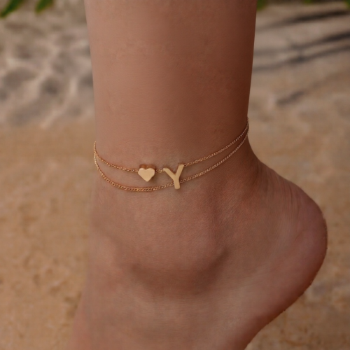 Woman wearing a Letter Y Heart Anklet with a double-layer chain and heart charm