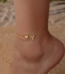 Woman wearing a Letter Y Heart Anklet with a double-layer chain and heart charm