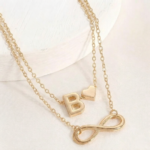 Double layer ankle bracelet featuring an Infinity symbol and a letter B charm on a woman's ankle