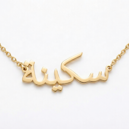 Copper necklace pendant spelling the name "Skina" in Arabic calligraphy