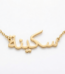 Copper necklace pendant spelling the name "Skina" in Arabic calligraphy