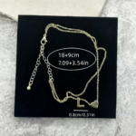 Woman wearing a letter L heart anklet with a double-layer chain and heart charm.