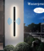 Long minimalist black LED wall light with acrylic enclosure on a modern exterior wall