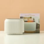 Black electric aroma diffuser with orange LED flame-effect mist.