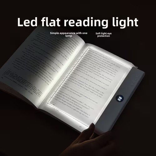 A transparent LED reading light panel placed over a paperback book page in a dark room.