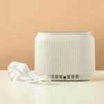 Black electric aroma diffuser with orange LED flame-effect mist.