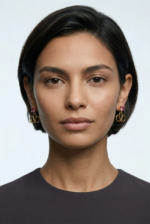 A close-up of Asia with Valentino Garavani VLogo earrings in gold-tone metal with rhinestones