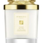 A Jo Malone London Orange Bitters Scented Candle in a limited-edition seasonal jar with a silver lid.