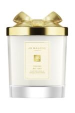 A Jo Malone London Orange Bitters Scented Candle in a limited-edition seasonal jar with a silver lid.