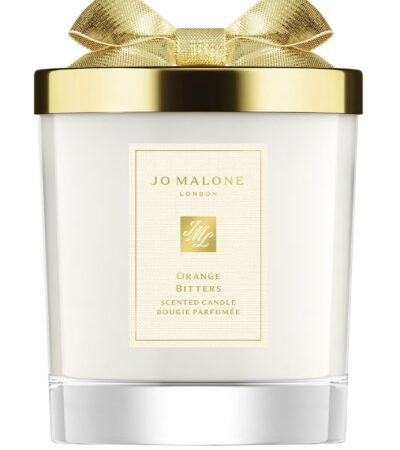 A Jo Malone London Orange Bitters Scented Candle in a limited-edition seasonal jar with a silver lid.