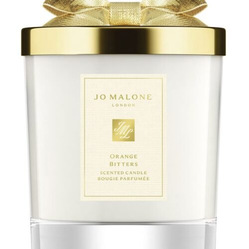 A Jo Malone London Orange Bitters Scented Candle in a limited-edition seasonal jar with a silver lid.