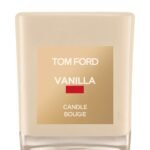 A Tom Ford vanilla-scented candle in a signature vanilla-hued glass jar with a cream label.