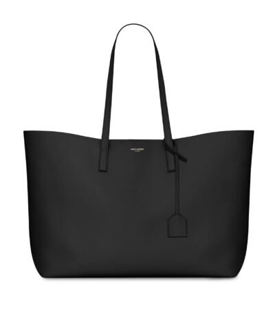 Saint Laurent East/West black leather tote bag with gold YSL charm and detachable pouch.