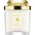 A Jo Malone London Pine & Eucalyptus Scented Candle in a decorative holiday glass jar with a silver lid.