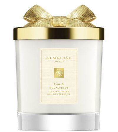 A Jo Malone London Pine & Eucalyptus Scented Candle in a decorative holiday glass jar with a silver lid.