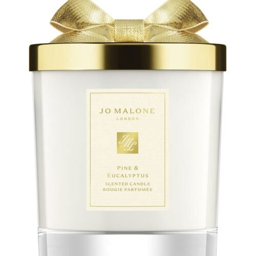 A Jo Malone London Pine & Eucalyptus Scented Candle in a decorative holiday glass jar with a silver lid.