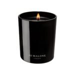 A minimalist black glass Jo Malone London Myrrh & Tonka Home Candle on a neutral background.